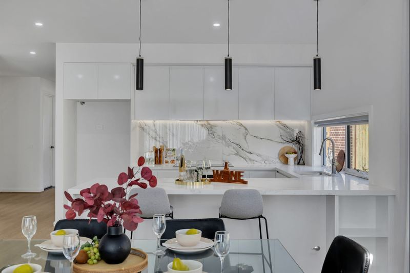Kitchen with stone benchtop, marble-look splashback and pendant lights
