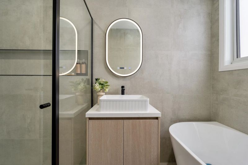 Main bathroom vanity with fluted basin and LED-lit mirror
