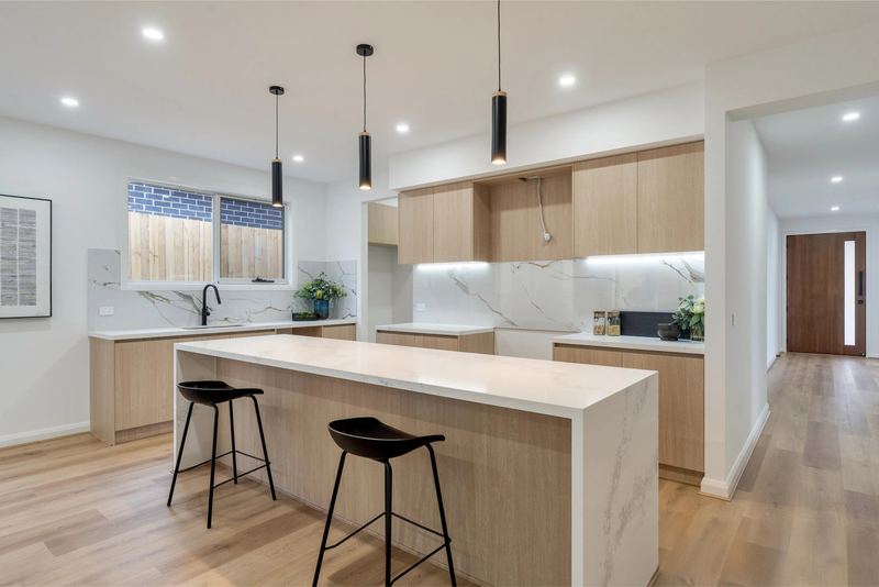 Kitchen with waterfall stone island and timber-look cabinetry
